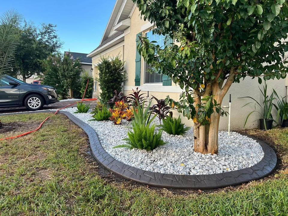White marble rock bed with dark stamped curbing wrapping a crape myrtle