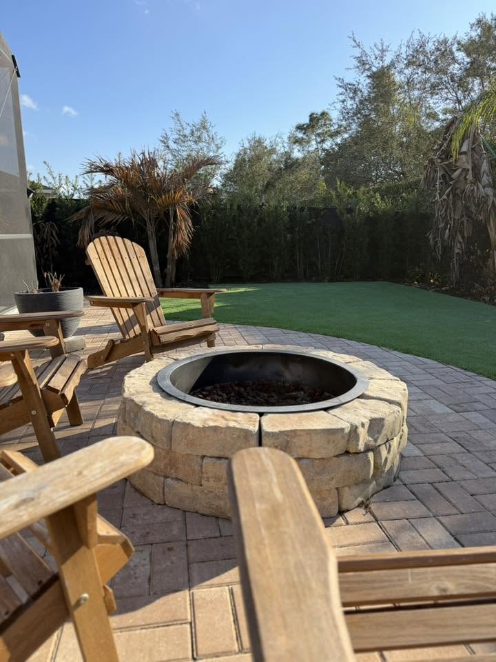 Stone firepit on a circular paver patio with Adirondack chairs at golden hour